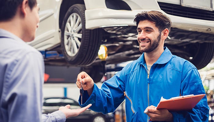 Service expert giving car key to customers